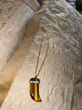 Tiger eye horn pendant two inches gold tone bale top of horn embellished with